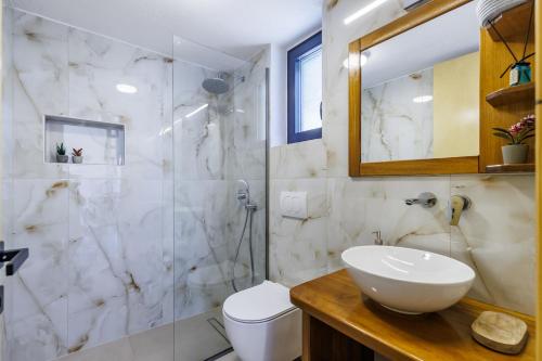 a bathroom with a toilet and a sink and a shower at Aether Retreat in Skopelos Town