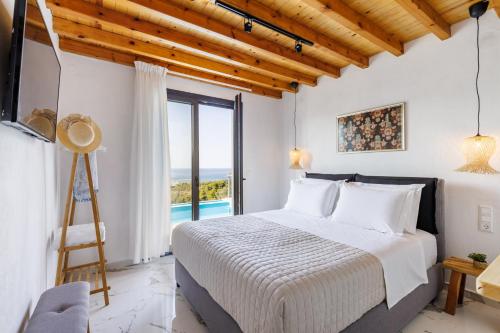 a bedroom with a bed and a view of the ocean at Aether Retreat in Skopelos Town