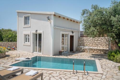 a villa with a swimming pool in front of a house at Stathis Home in Exanthia