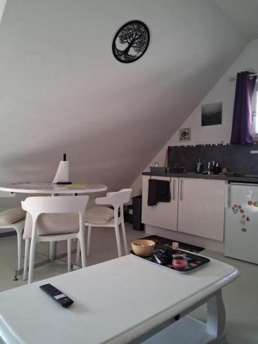 a kitchen with a table and a clock on the wall at VÉNUS in Dessenheim