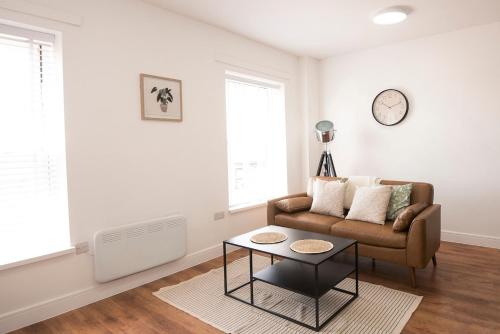 a living room with a couch and a table at Stylish 2-Bed Apartment in Penarth Town Flat 2 in Cardiff