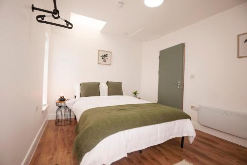 a bedroom with a large bed with white walls at Stylish 2-Bed Apartment in Penarth Town Flat 2 in Cardiff
