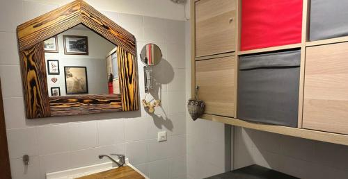 a bathroom with a mirror and a sink at Casa Richardette Relax in the Woods in Sauze d'Oulx