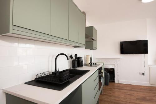 a kitchen with a sink and a counter top at Stylish 2-Bed Apartment in Penarth Town Flat 2 in Cardiff
