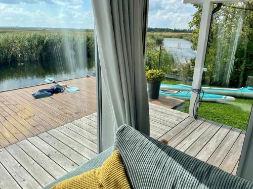 Una habitación con una puerta corrediza de vidrio que da a un lago. en Baltic Waterfront Yacht House - PRIVATE Garden & Watersports Included, en Świnoujście