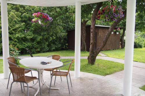 a white table and chairs on a patio at Männi Guesthouse in Haapsalu