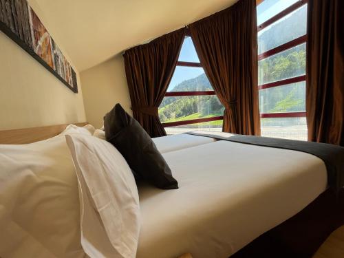 a bedroom with a bed with a large window at Wuau! Hotel Galanthus & Spa in Soldeu