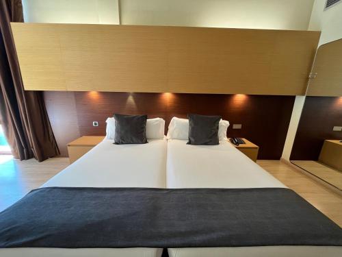 a large white bed with two pillows on it at Wuau! Hotel Galanthus & Spa in Soldeu