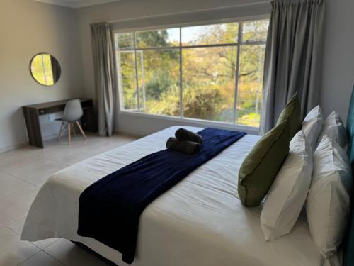 a large bed in a room with a large window at Riverhaven Cottage in Muldersdrift