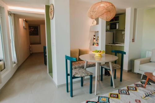 a dining room and living room with a table and chairs at Écrin bleu - Vue mer & piscine in La Marsa