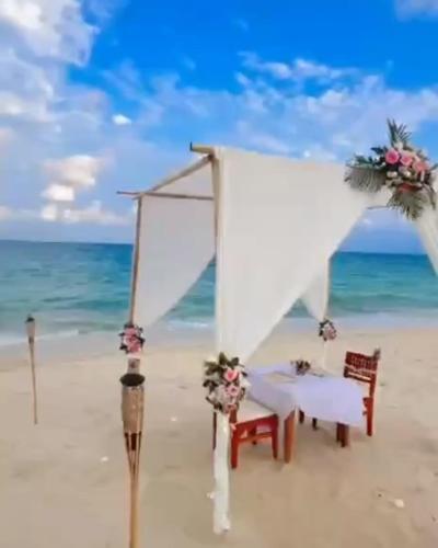 a white altar on a beach with a table and chairs at Aura Samui Best Beach Hotel - SHA Plus in Lamai