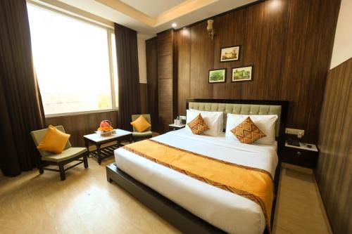 a hotel room with a large bed and a window at Foxoso Fiori Hotel in Jaipur