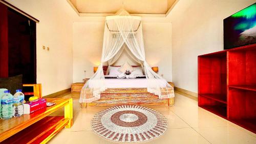 a bedroom with a bed with a canopy at The Cliff Villa in Kubupenlokan