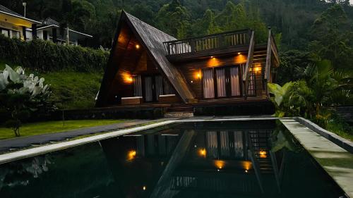 a house with a swimming pool in front of a house at The Cliff Villa in Kubupenlokan
