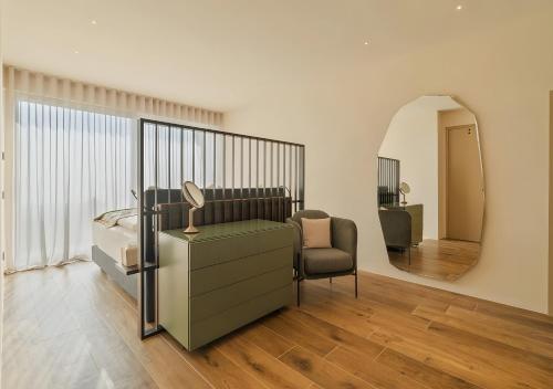 a bedroom with a bed and a chair and a mirror at Villa Vallonga in Bardolino