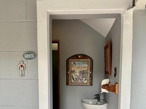 a bathroom with a sink and a picture on the wall at Thyme and Again B&B Estcourt in Estcourt