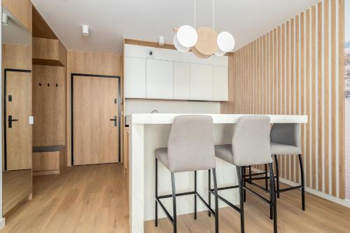a kitchen with a bar with two stools at Sarbinove City Apartments in Sarbinowo