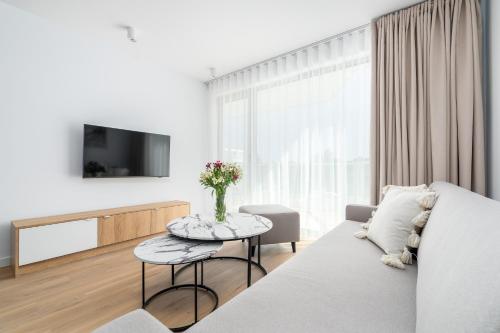 a white living room with a couch and a table at Sarbinove City Apartments in Sarbinowo