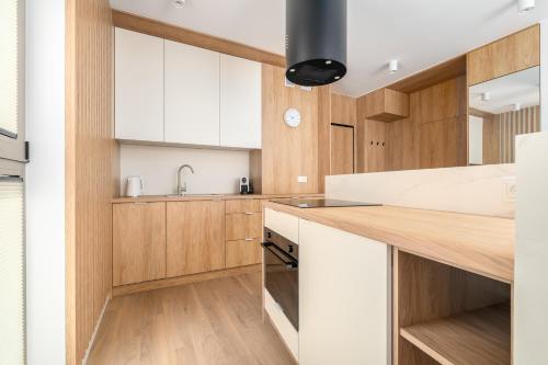 a kitchen with wooden cabinets and a counter top at Sarbinove City Apartments in Sarbinowo