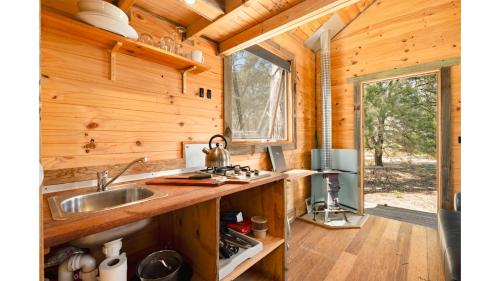 a kitchen in a log cabin with a sink and a window at Northern Grampians Sanctuary by Tiny Away in Dadswells Bridge