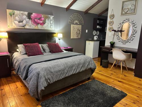 a bedroom with a bed and a desk and a chair at Thyme and Again B&B Estcourt in Estcourt