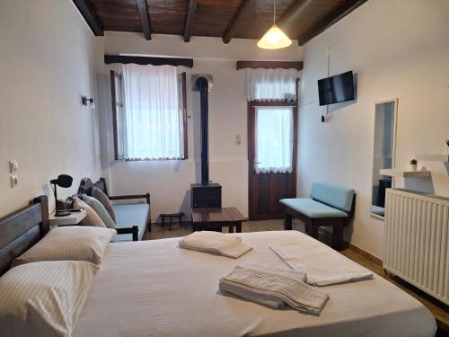 a bedroom with a bed and a living room at Kastania Gi in Palaios Panteleimon