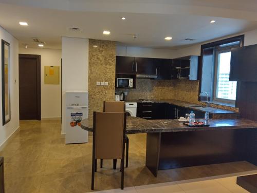 a kitchen with a large island in a room at Tulip Creek Hotel Apartments in Dubai