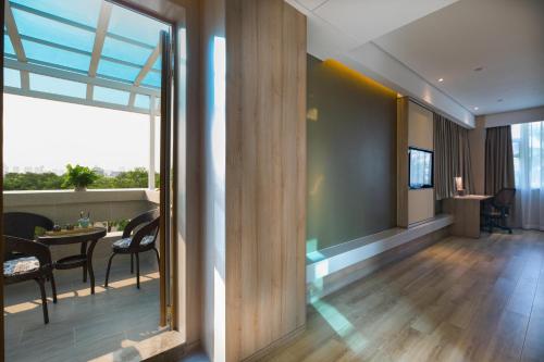 a living room with a table and chairs and a large window at Atour Hotel Xiamen Jimei University in Xiamen