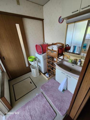 a small bathroom with a sink and a mirror at 旅の宿さくら庵 in Tanabe