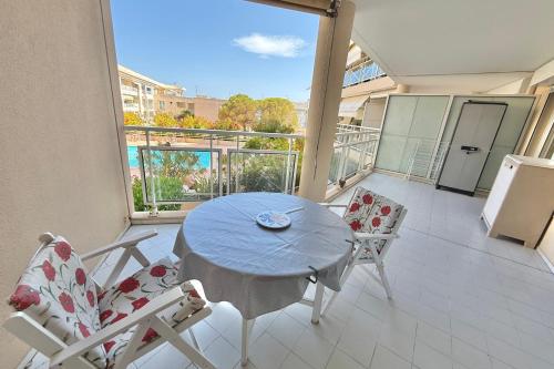 une pièce avec une table et des chaises sur un balcon dans l'établissement 2-Bedroom Apartment with Garage Pool View Golfe-Juan, au Golfe-Juan
