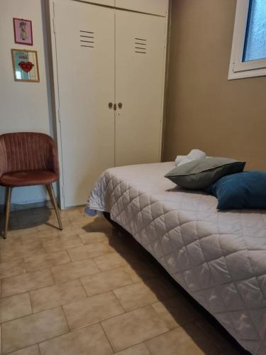 a bedroom with a bed and a chair and a closet at Leonidas Private Apartment in Sparta in Sparti
