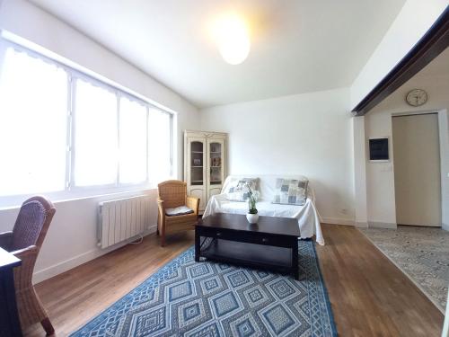 - une chambre avec un lit et une table sur un tapis dans l'établissement La Tremblade - MAISON mitoyenne en CENTRE-VILLE - CENTRE et PORT A PROXIMITE, à La Tremblade