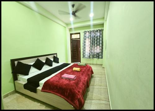 瓦拉纳西Hotel Devans Palace Stay Near Kashi Vishwanath Temple - Fully Air Conditioned rooms - Free wi-fi- & Parking - Best - Hotel的一间卧室配有一张带红色毯子的床