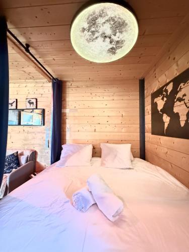 a bedroom with a bed in a wooden room at La Cachette du Domaine du Moulin avec son spa privé en option in Saint-Laurent-dʼAndenay