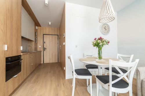 a kitchen and dining room with a table and chairs at Sarbinove City Apartments in Sarbinowo