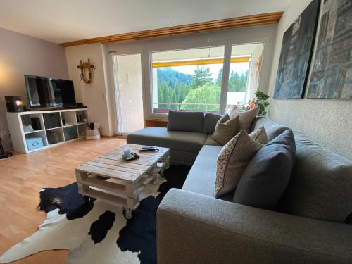Una sala de estar con un sofá y una mesa de café. en Rothornblick 28 by Arosa Holiday, en Arosa