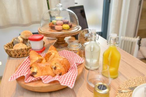 a table with a plate of bread and drinks and a bottle of milk at La Cachette du Domaine du Moulin avec son spa privé en option in Saint-Laurent-dʼAndenay