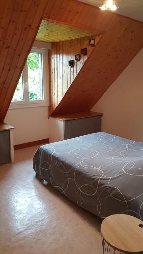 une chambre avec un lit dans un grenier dans l'établissement La Maison des Étoiles, à Marcey-les-Grèves