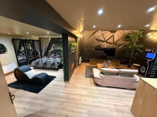 a living room with two couches and a television at LUXURY VENDÔME - Loft - suite de luxe - Jacuzzi - Appartement entier in Vendôme