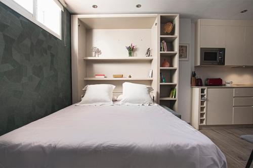 Un dormitorio con una cama grande con dos almohadas. en Apartamento Las 3 Terrazas, en Cádiz