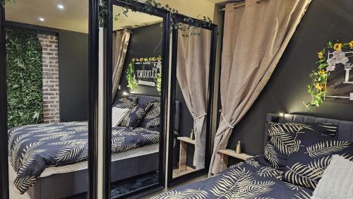 a mirrored room with two beds and a mirror at LUXURY VENDÔME - Loft - suite de luxe - Jacuzzi - Appartement entier in Vendôme