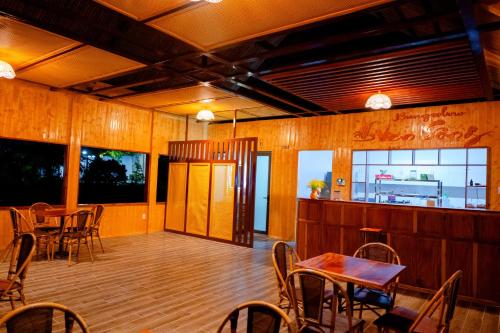 a dining room with tables and chairs and windows at Bungalow Ven Sông in Ấp Phú Hòa (2)