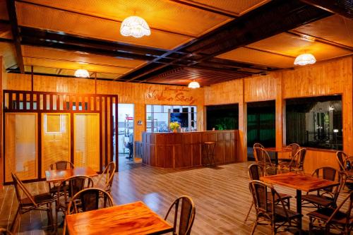 a restaurant with wooden tables and chairs in a room at Bungalow Ven Sông in Ấp Phú Hòa (2)