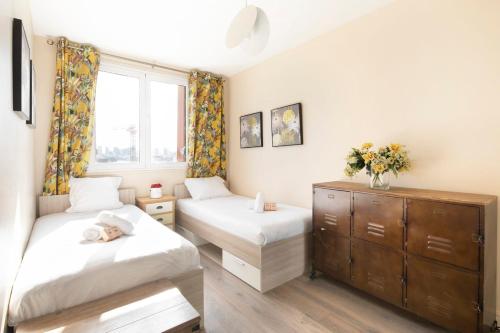 une chambre avec deux lits et une commode et une fenêtre dans l'établissement Gorgeous apartment Near Paris - 5P, à Clichy