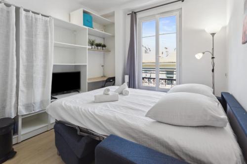 une chambre avec un grand lit blanc et une fenêtre dans l'établissement Le Citadin - Hypercentre - Cosy - Shopping - WIFI, à Nice