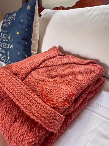 a red blanket sitting on top of a bed at Tal Jordan Complex in Għarb