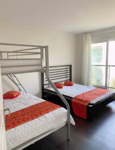 deux lits superposés dans une chambre avec fenêtre dans l'établissement Maison 2 Chambres, à Mimizan-Plage