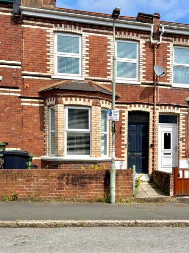 a brick house with a black door on a street at Newly Refurbished City Centre House With Parking in Exeter