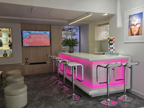 a pink bar with stools in a waiting room at South Beach Camps Bay Boutique Hotel in Cape Town
