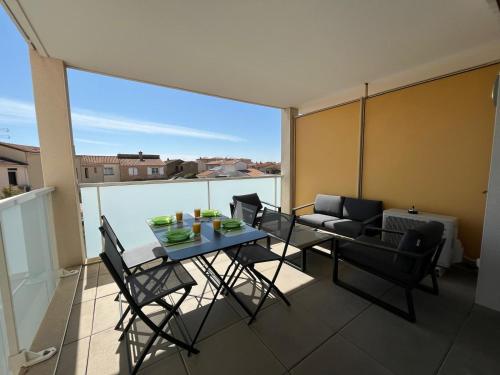 d'un balcon avec une table, des chaises et un canapé. dans l'établissement Gaul, à Valras-Plage